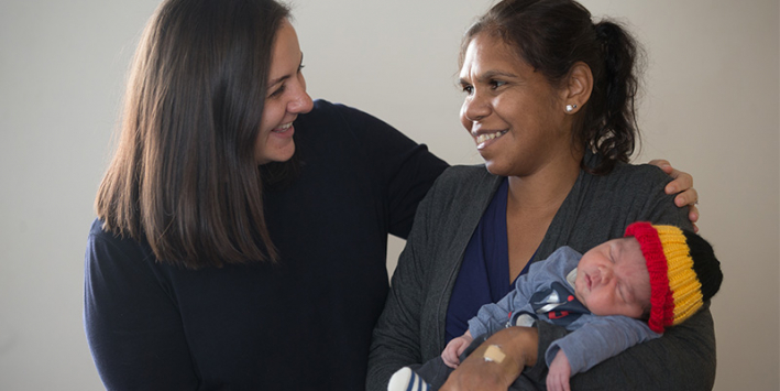 Staff member with mother and baby