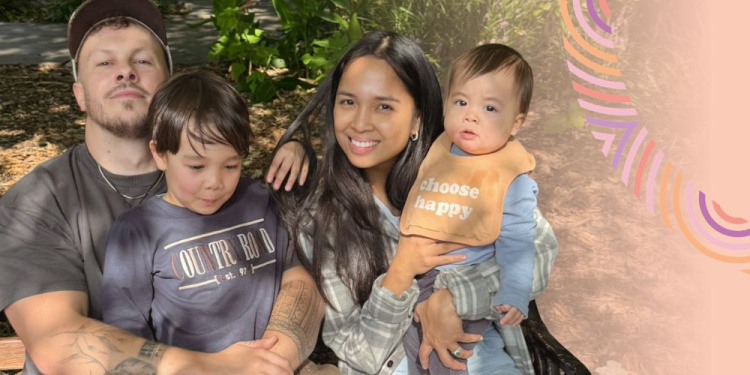 Family of four smiling into the camera. 